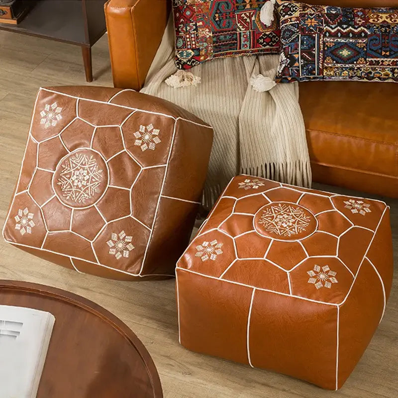 Pouf carré cuir marron utilisé comme élément de décoration dans un salon