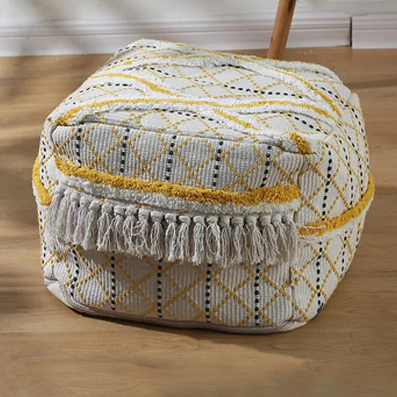 Pouf carré doré en tissu texturé placé dans une décoration orientale moderne