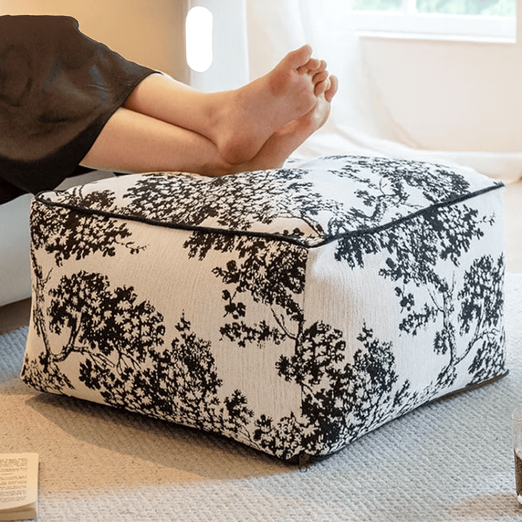 Pouf noir et blanc au motif feuillage, idéal pour une ambiance chambre cocooning