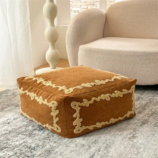 Pouf carré Sésame Ambre en tissu brodé utilisé comme élément déco
