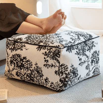 Pouf noir et blanc au motif feuillage, idéal pour une ambiance chambre cocooning